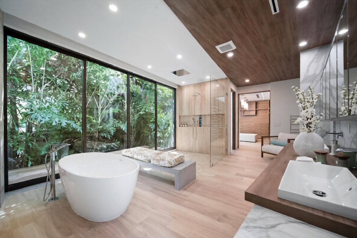 Frameless glass shower in a primary bath with a floor-to-ceiling garden window, Brickell Avenue Spec Home