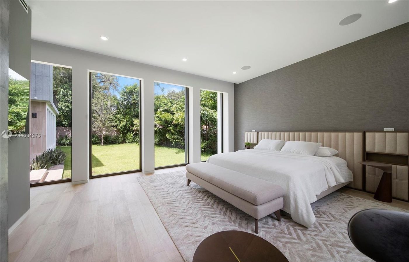 Bedroom with tall windows looking out to the lawn