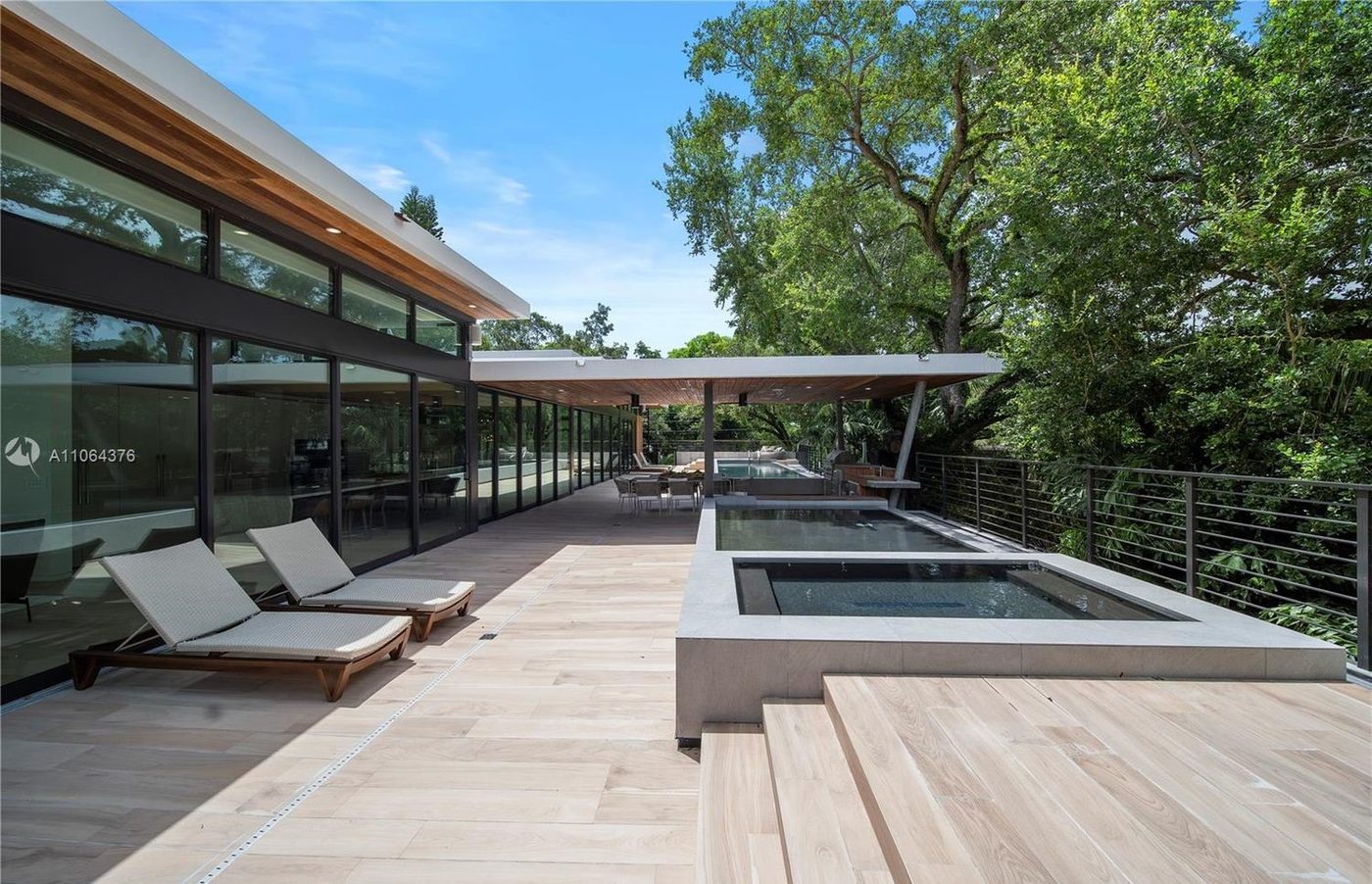 Pool deck along the glazed pavilion, with railings at the deck edge