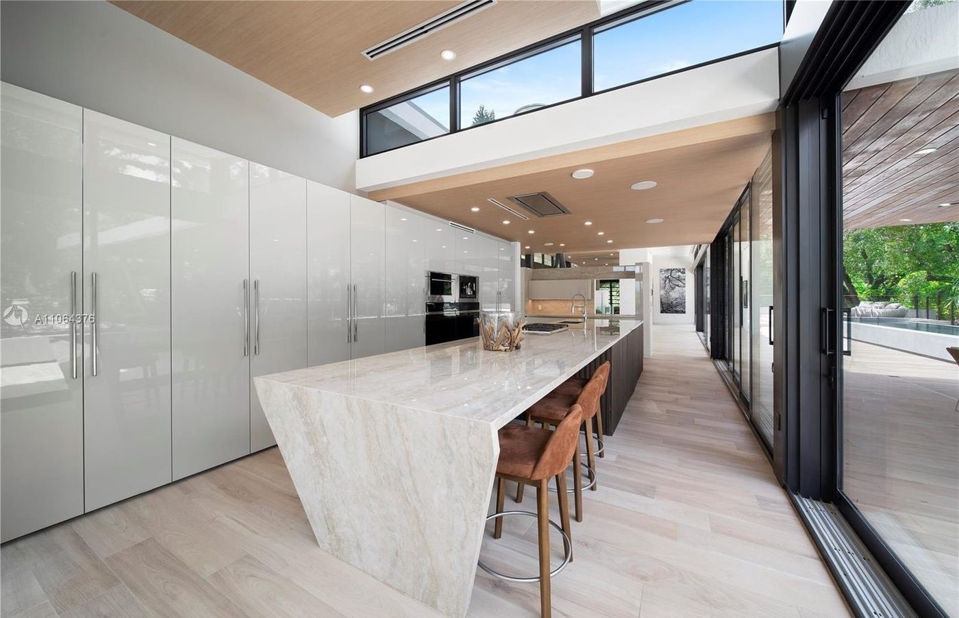 Kitchen lined with clerestory windows and sliding doors to the garden