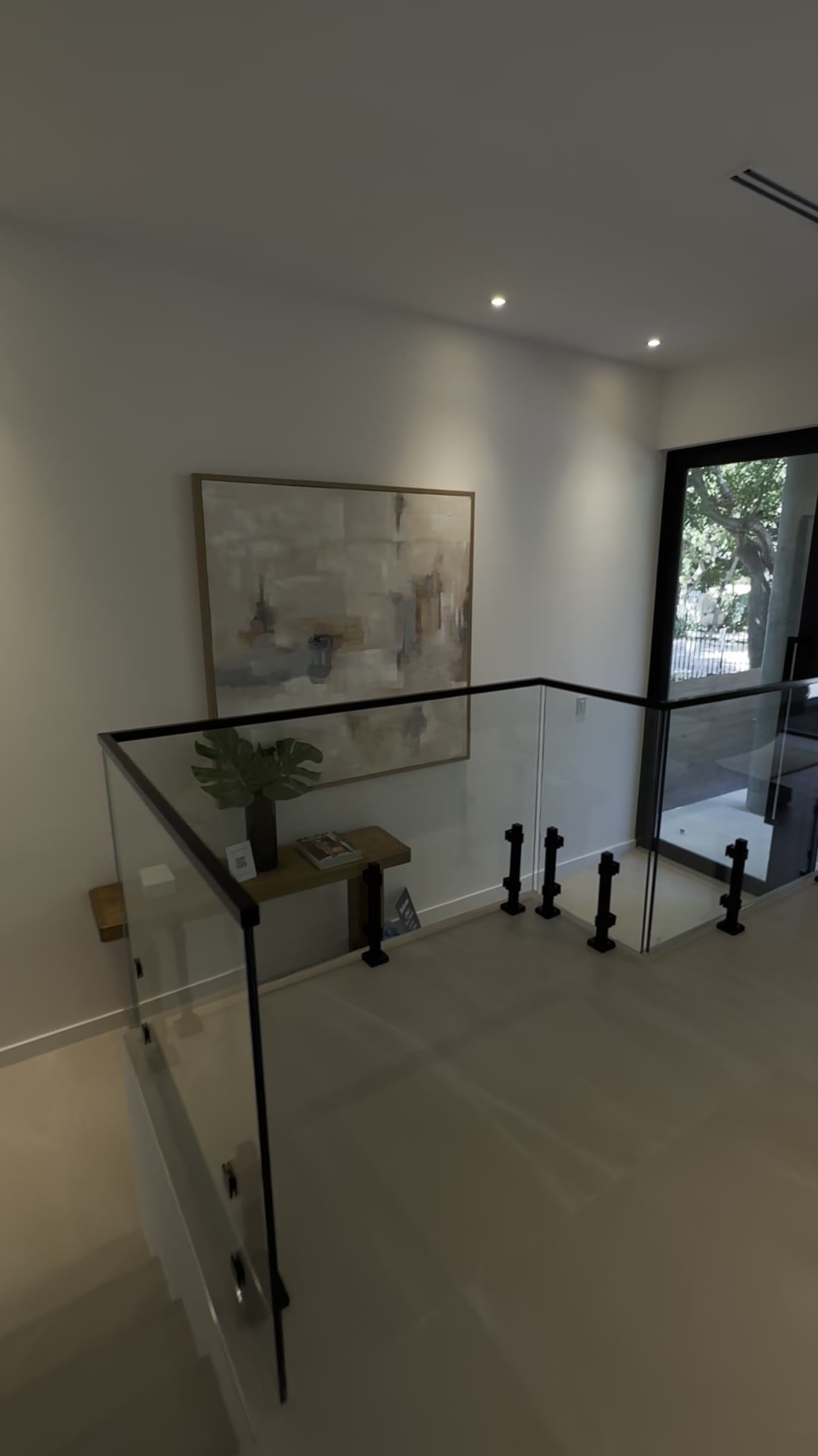 Glass guard wrapping the upper landing at the stair opening