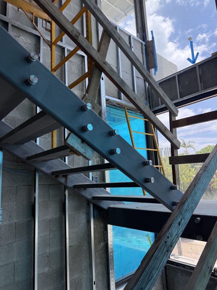 Standoffs set on a steel stair stringer, ready for glass