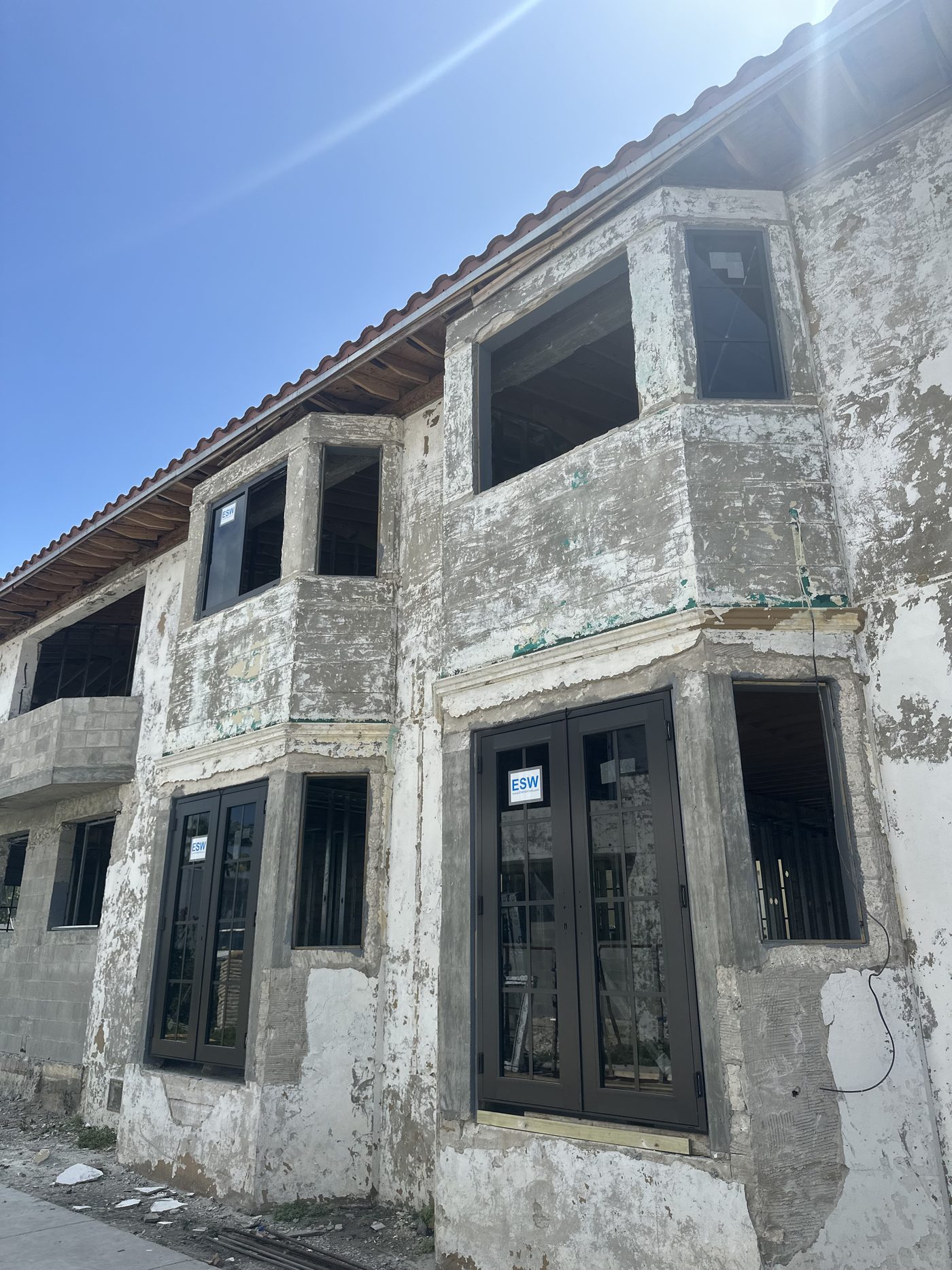New divided-lite impact windows and French doors set into the historic bays
