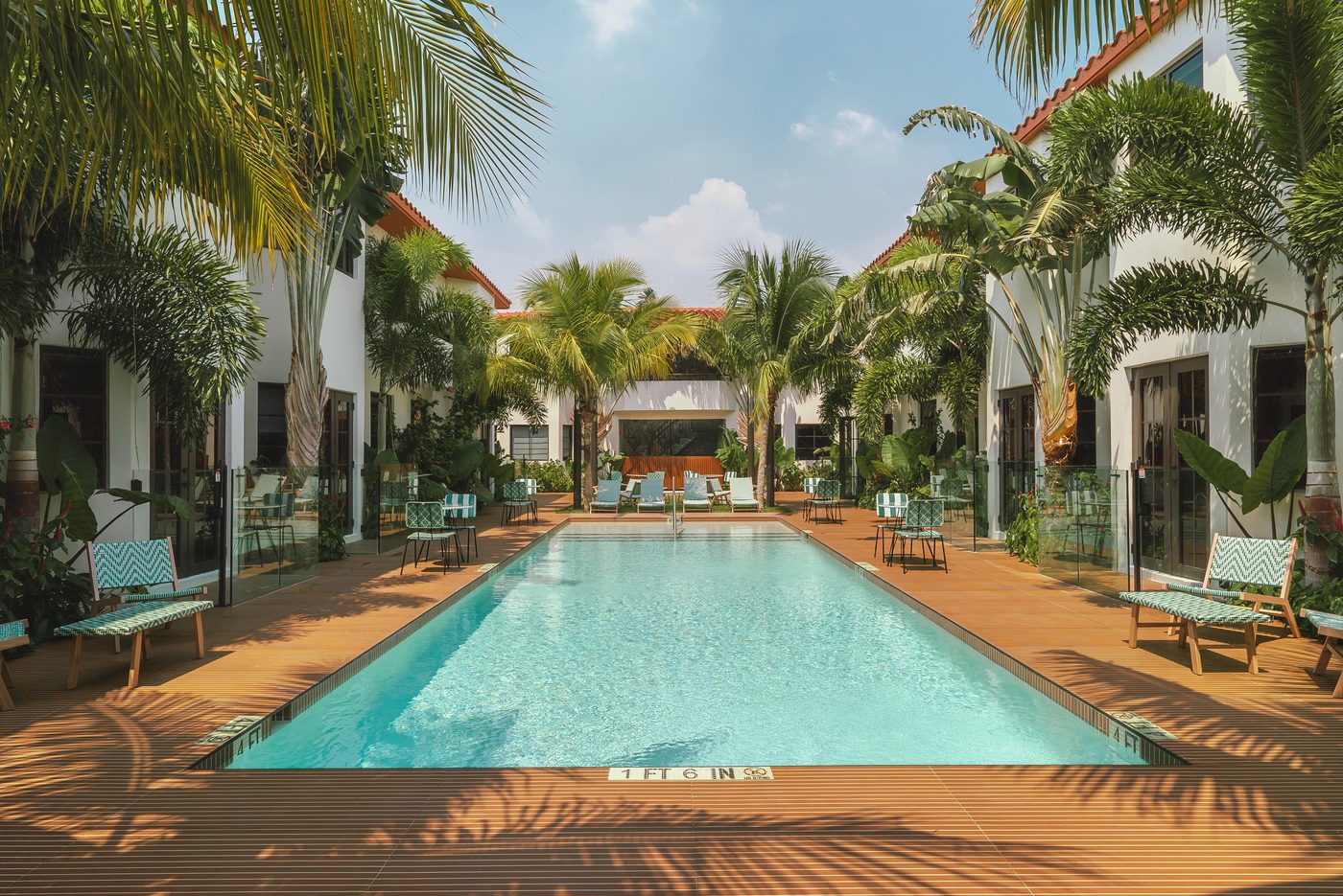 Harding Hotel courtyard pool lined with divided-lite impact French doors and frameless glass pool fencing
