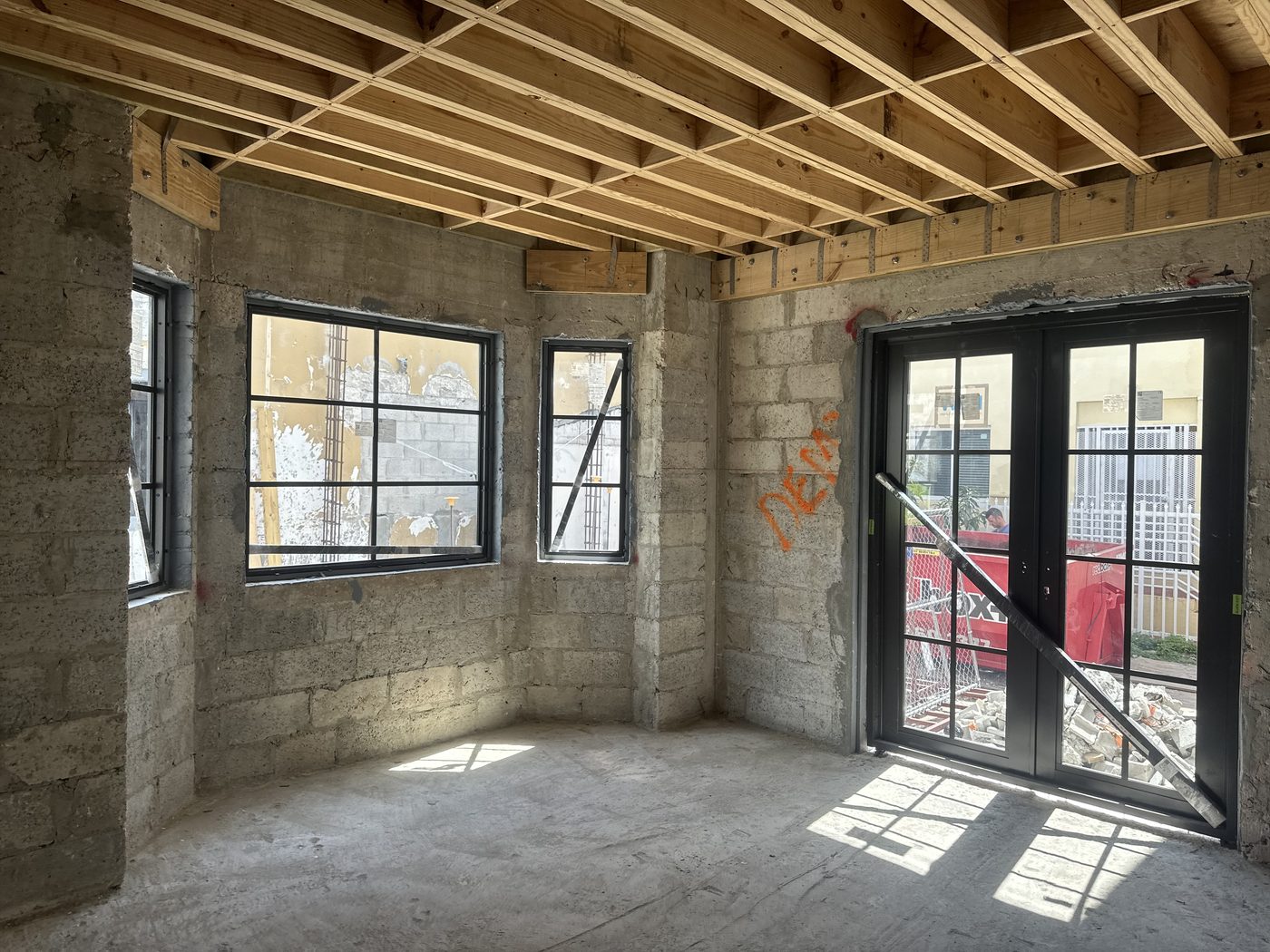 Bay room with divided-lite windows and French doors, before interior finishes