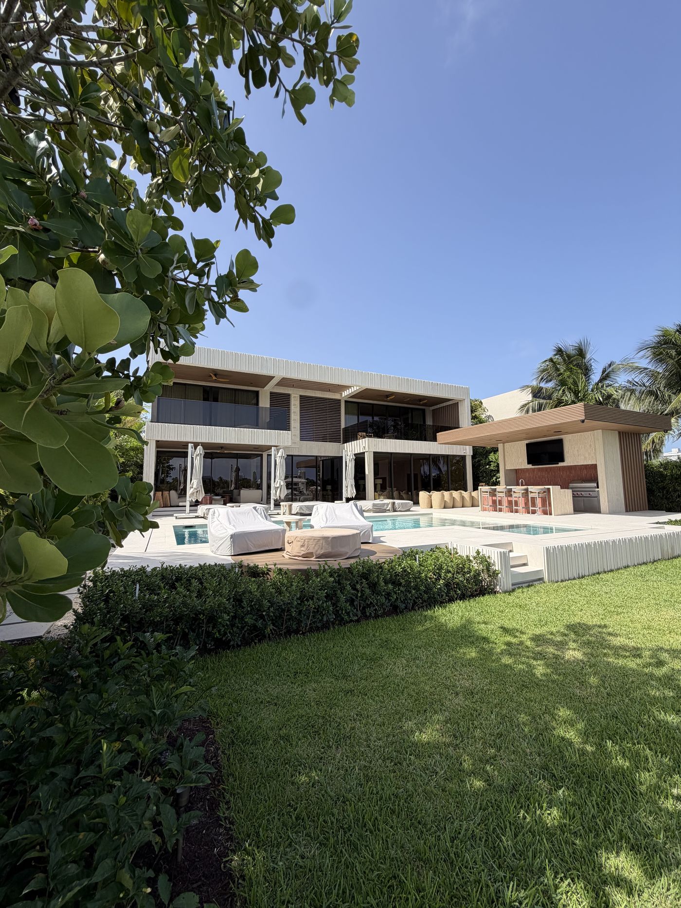 Rear of the Surfside Residence: floor-to-ceiling glass, glass balcony railings and pool terrace