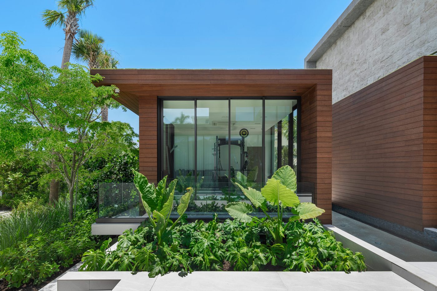 Glass pavilion set into the tropical garden