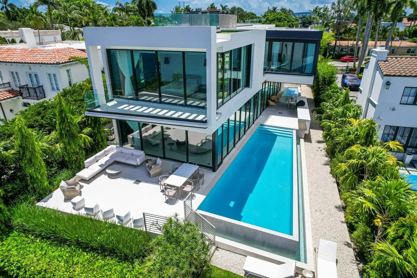 Modern spec home on Hibiscus Island with floor-to-ceiling glass, glass balcony railings and a lap pool