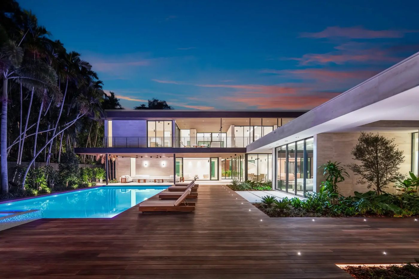 Kiaora Residence at dusk: two-story glass facade and covered terrace over the pool deck