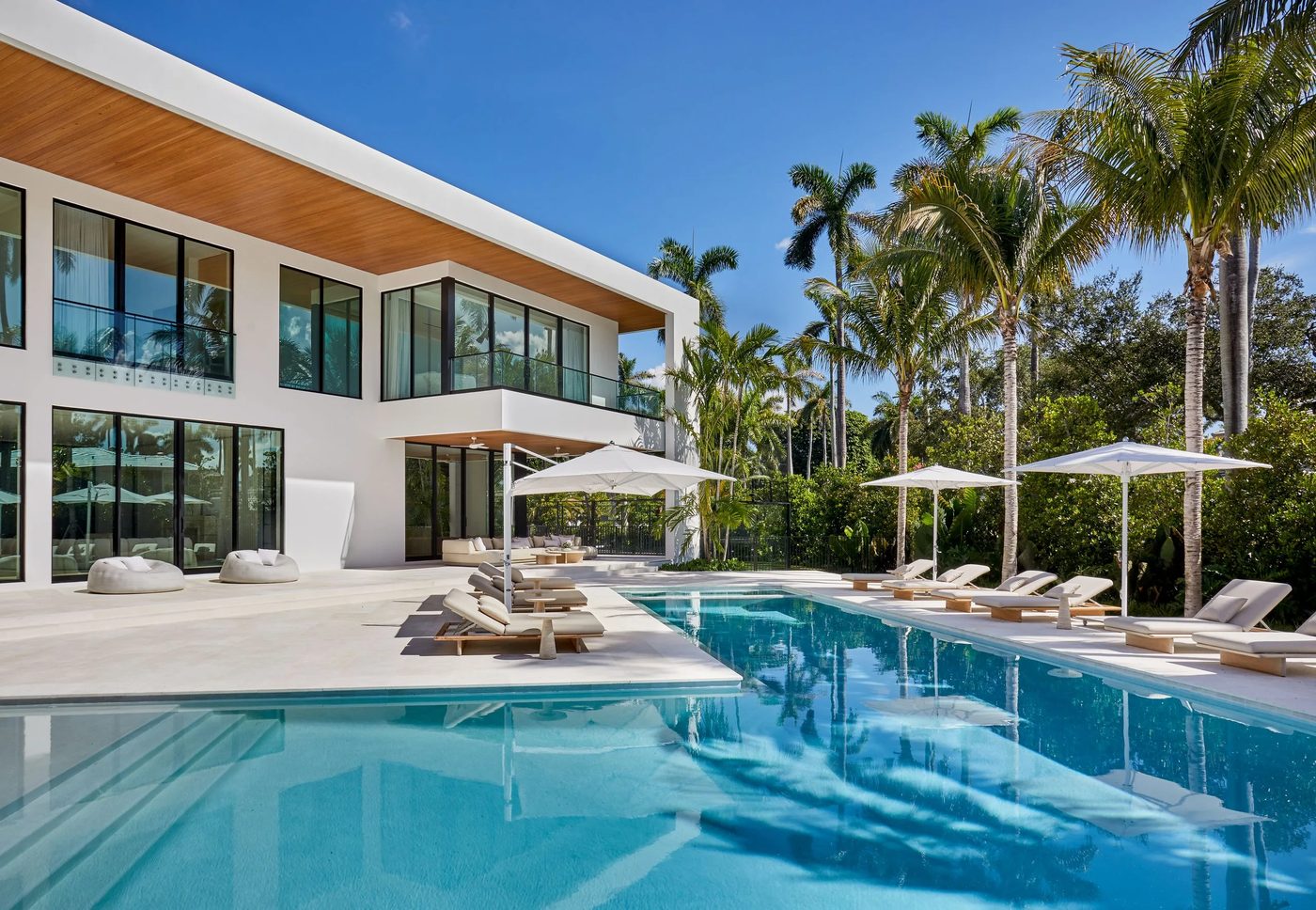 La Gorce Island custom home with standoff glass balcony railings above the pool terrace