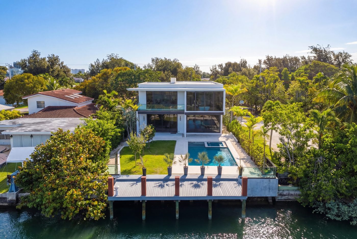 Aerial view of the Normandy Shores spec home on the waterway with glass balcony and seawall railings