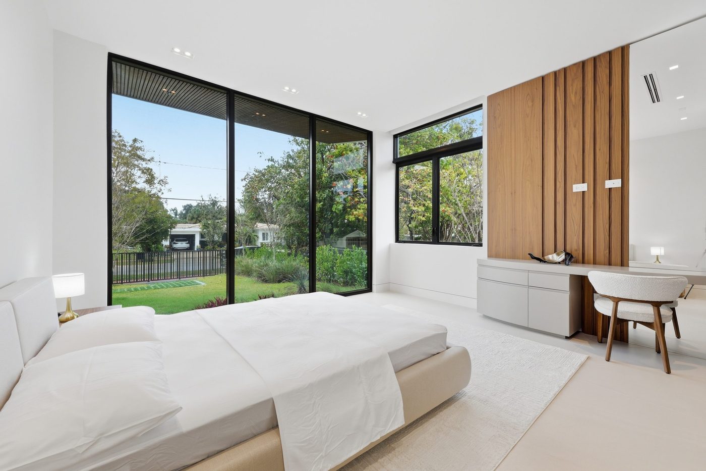 Bedroom with a full-height corner window wall and casement windows