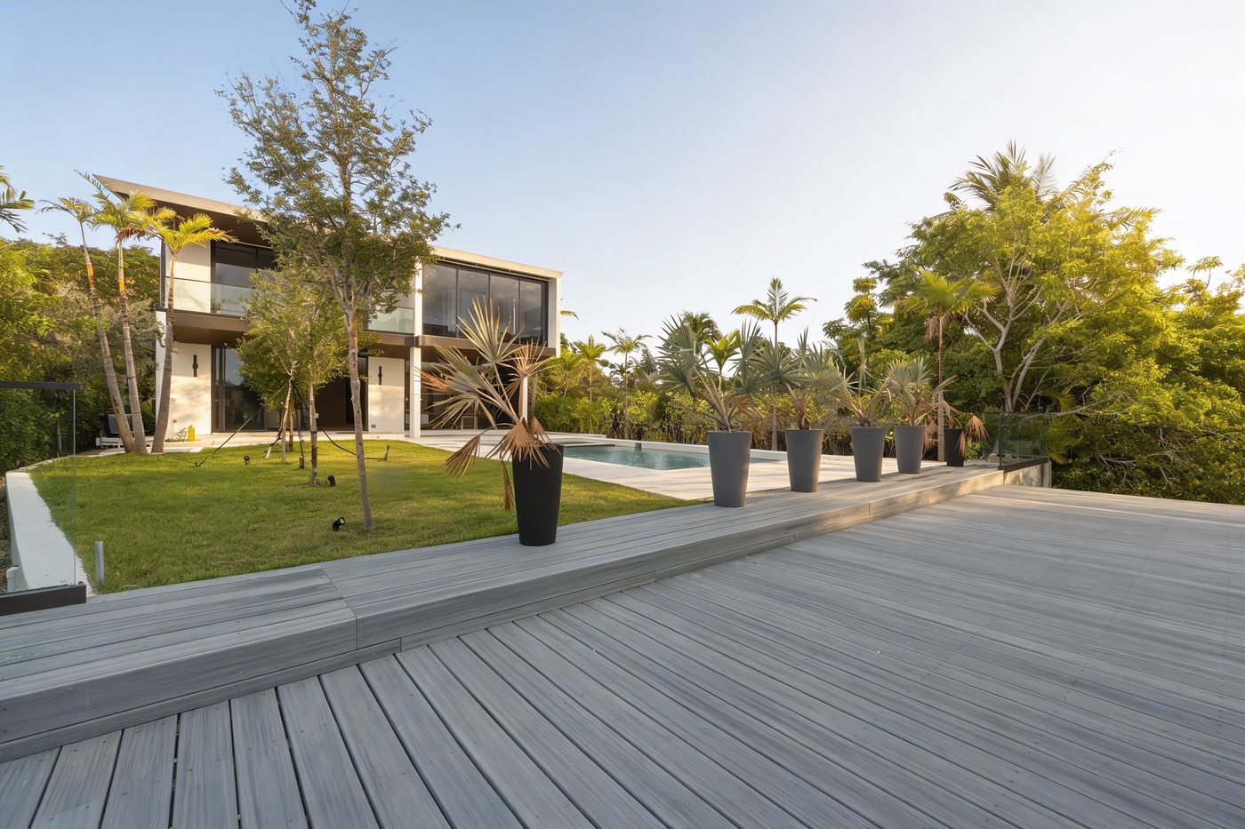 Rear of the house from the dock deck, with glass railings at the seawall