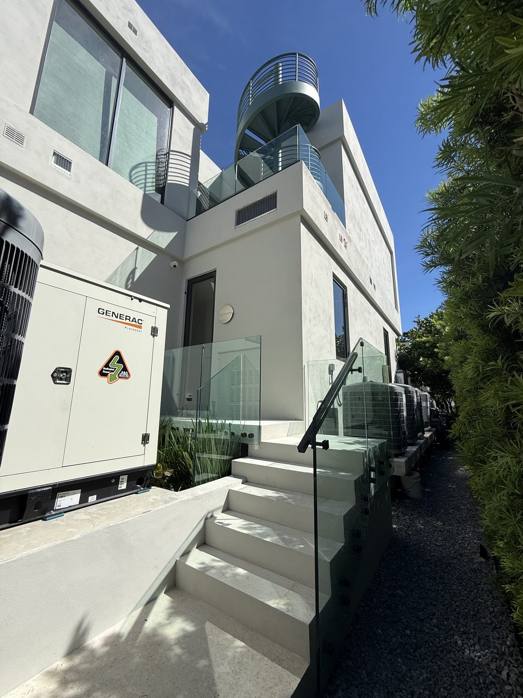 Frameless glass guards on standoffs along the side stair