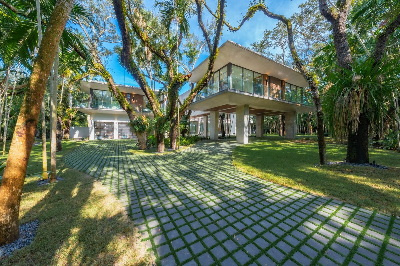 Raised glass pavilion and balconies over the driveway beneath the oaks