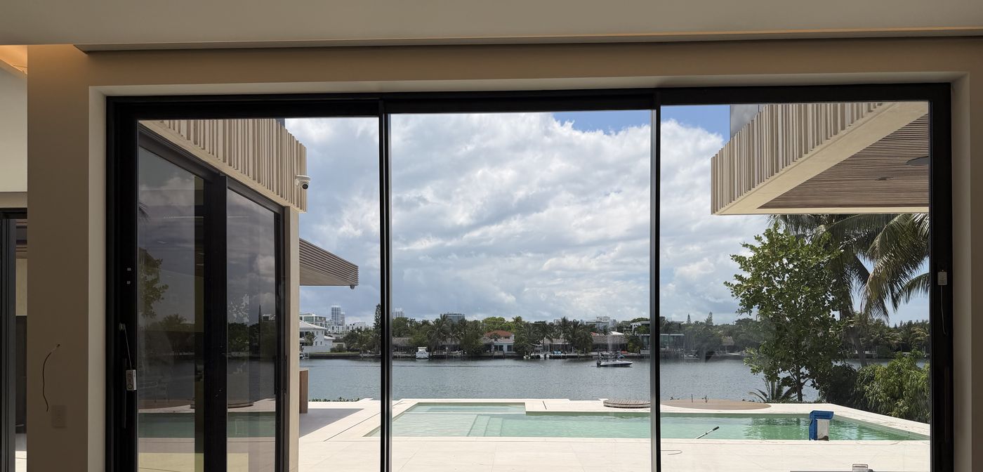 Eurowall flush-track sliding doors opening the living room to the pool terrace and bay