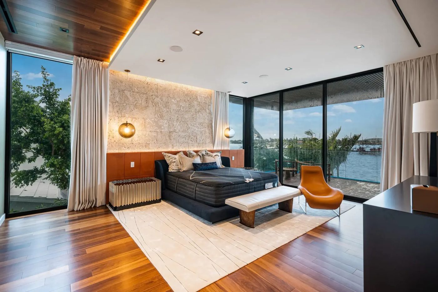 Bedroom with corner glazing and sliding doors to a bay-view terrace