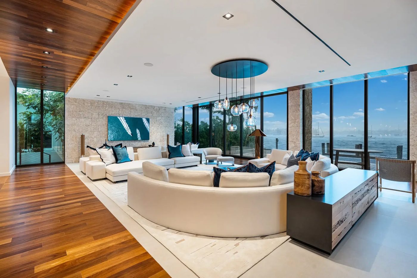 Living room with full-height glazing on two sides and bay views